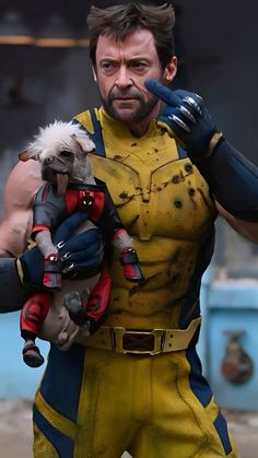 a man dressed as wolverine holding a stuffed animal in his hands and wearing gloves on