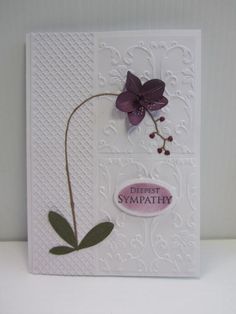 a white card with purple flowers and the words deepest sympathy written on it's side