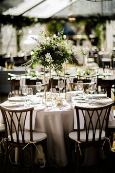 the table is set with white linens and place settings