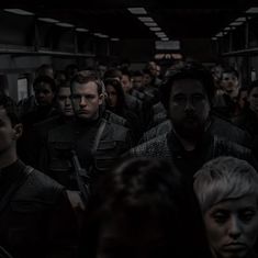 a group of people are standing in a train car with their backs turned to the camera