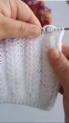 someone is knitting a white sweater with scissors