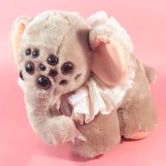 a small stuffed animal on a pink background