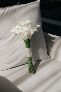 a bouquet of white flowers sitting on top of a bed