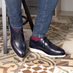 a person sitting at a table wearing blue shoes