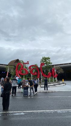 people standing in front of a large red sign that says boo on it's side