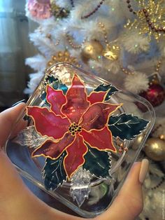 a hand holding a clear case with a red poinsettia decoration on it