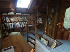 the interior of a wooden cabin with bookshelves