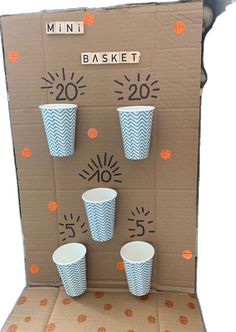 an open cardboard box with cups on it