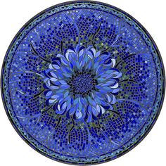 a blue glass plate with a flower design on the front and center piece is shown