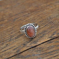 Sunstone Gemstone Ring - Oregon Sunstone Cabochon Ring - Sunstone Jewelry - Sunstone and 925 Sterling Silver Ring - Orange Sunstone Ring Sunstone is known as the stone of warmth, and benevolence. Sunstone is also said to help support mental clarity and physical strength. In ancient Greece sunstone was considered an invigorating stone. In various Native American tribes Sunstone was used in medicine wheel rituals, and it has even been used as a good luck charm for gamblers. Sunstone is said encour Silver Sunstone Jewelry With Gemstone, Silver Sunstone Jewelry With Natural Stones, Sterling Silver Rings With Round Stone Setting, Sterling Silver Round Opal Ring, Sterling Silver Rings With Natural Round Stones, Sunstone Jewelry With Round Natural Stones, Oval Silver Opal Ring With Detailed Stones, Sunstone Jewelry, Oregon Sunstone