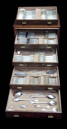 a set of four wooden drawers with silverware in them on top of each other