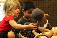 two children are playing with dolls in a basket