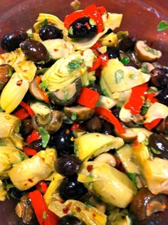 a bowl filled with olives, artichokes and other foodstuffs