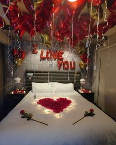 a bed that has some balloons on the headboard and lights hanging from the ceiling