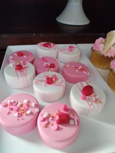 cupcakes are decorated with pink and white icing