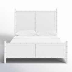 a white bed with bamboo headboard and foot board in the middle, against a plain background