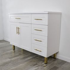 a white cabinet with gold handles and drawers