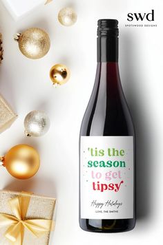 a bottle of wine next to christmas ornaments and presents on a white background with the words tise season i've got upsy