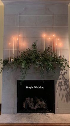 the fireplace is decorated with candles and greenery