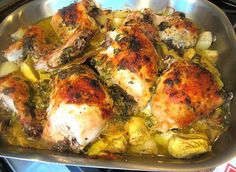 chicken and artichokes are cooking in a pan