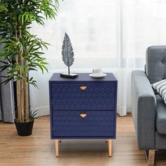 a living room with a couch, chair and side table next to a potted plant