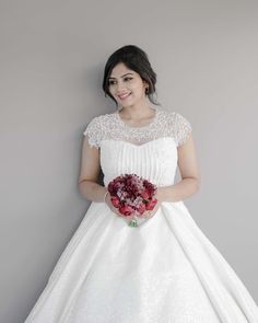 a woman in a white dress holding a bouquet of flowers