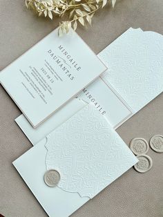 the wedding stationery is laid out on top of the table with flowers and wax