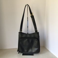 "This Liz Claiborne Black Faux Leather Shoulder Bag is in very good vintage condition. The exterior of the bag is black faux leather. The interior of the bag is lined with solid black cotton fabric. The interior main section has one zippered pocket, with a flap closure. There is one exterior slip pocket. In addition, there is an additional zip around section. This section contains two slip pockets, four card holders, and three pen holders. This bag measures approximately: Length: 9.25\" Height: Classic Black Shoulder Bag With Zipper Pocket, Vintage Black Satchel With Zipper Closure, Vintage Black Shoulder Bag With Leather Backing, Vintage Black Bags With Leather Backing, Vintage Black Bag With Zipper Pocket, Black Vintage Bag With Zipper Pocket, Black Formal Satchel With Zipper Pocket, Timeless Bags, Black Cotton Fabric