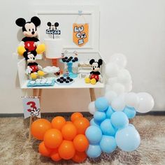 a mickey mouse birthday party with balloons and decorations