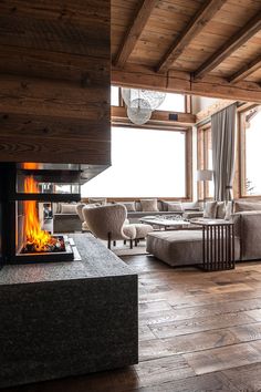 a living room filled with furniture and a fire place in the middle of an open floor plan