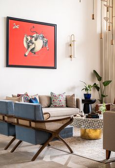 a living room filled with furniture and a painting on the wall above it's couches