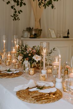 a table is set with candles and flowers for a formal dinner or wedding reception,