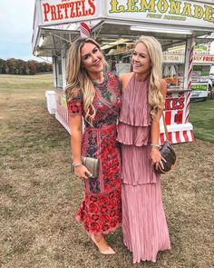 two women standing next to each other in front of a food cart at an event