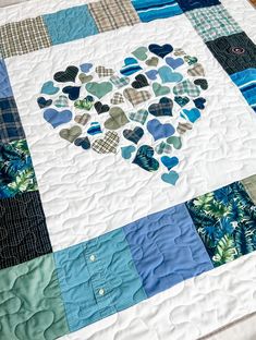 a quilt made to look like a heart with blue and green hearts on the center