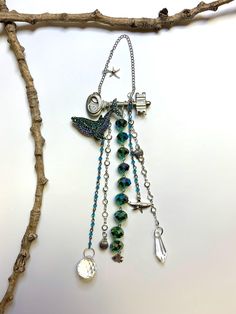 a tree branch with beads and charms hanging from it