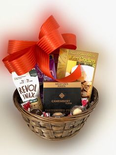 a basket filled with assorted chocolates and candies next to a red bow