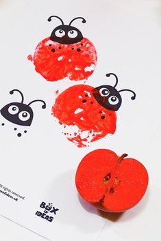 two red apples sitting on top of a white paper