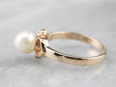 This pearl ring would make a lovely romantic gift! Subtle heart accents on the shoulders form an openwork design that is feminine and sweet, drawing the eye to the pearl at the center. Diamonds add the perfect touch of sparkle to this charming ring! Metal: 14K Yellow Gold Gem: Pearl Gem Measurements: 6.7 mm, Round Accents: 2 Diamonds totaling .04 Carats, SI2 in Clarity, G in Color Ring Size: 7 Marks: "585" Stamped on the inside band Elegant Adjustable Yellow Gold Pearl Ring, Classic Gold Pearl Ring With Pearl Charm, Classic Yellow Gold Pearl Ring With Charm, Gold Round Pearl Charm Ring, 14k Gold Round Cut Pearl Ring - Fine Jewelry, Yellow Gold Sapphire Ring, Gold Heart Ring, Cameo Ring, Right Hand Rings