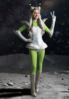 a woman dressed in green and white standing on the moon with her hands up to one side