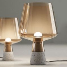 two lamps that are next to each other on a table with one light turned off