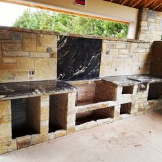 an outdoor kitchen with stone ovens and cabinets