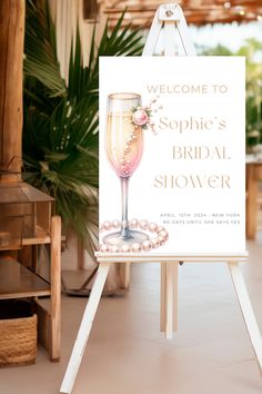 a welcome sign for a bridal shower is displayed on an easel in front of a palm tree