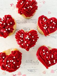 cupcakes decorated with red icing and white sprinkles in the shape of hearts