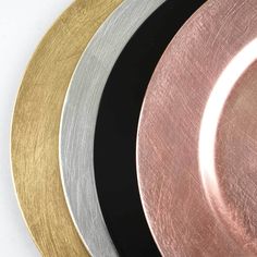 four different colored plates with gold, silver, and black rims on white background