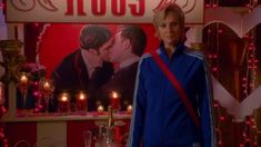 a woman standing in front of a sign with candles on it and a man kissing her