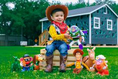 a little boy sitting on top of a wooden crate with toy farm animals around him