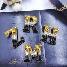 the letters r, h, and m are made out of beaded beads on a blue surface