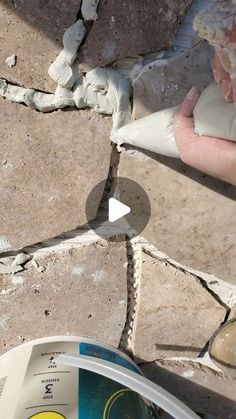 a person is making something out of clay on the ground next to a cement paver