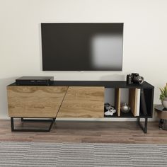 an entertainment center with a flat screen tv mounted on it's sideboard in a living room