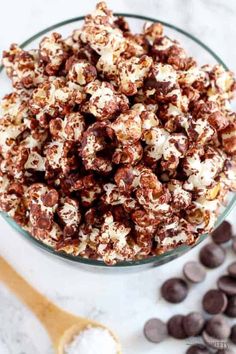 a bowl filled with chocolate covered popcorn on top of a table